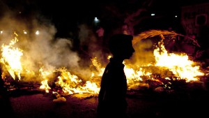In this Sunday, March 17, 2013 file photo, an Egyptian activist walks past burning tires during an anti-Muslim Brotherhood protest, in Cairo, Egypt. (AP)