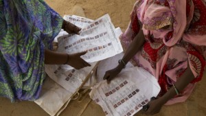 Voters look for their names on voter lists scattered on the ground at the main polling place in Kidal, Mali, on Sunday, July 28, 2013. (AP Photo/Rebecca Blackwell)