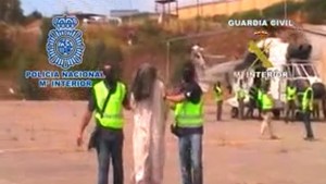 An image grab taken from a handout video released on June 22, 2013 by the Spanish Interior Ministry shows members of the Spanish security forces detaining one of the eight unidentified suspected terrorists arrested in Ceuta on June 21. Spanish security forces on June 21 broke up an Al-Qaeda-linked network in north Africa suspected of sending fighters to Syria, arresting eight people in early morning raids. Police launched operations against the network in Ceuta, a Spanish territory in north Africa. (AFP PHOTO/SPANISH INTERIOR MINISTRY)