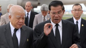Cambodian Prime Minister Hun Sen (C) speaks to Prince Norodom Chakrapong (L) at Phnom Penh International Airport on August 12, 2013. (AFP PHOTO/TANG CHHIN SOTHY)