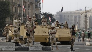 In this file photo taken on Friday, August 16, 2013, Egyptian army soldiers take their positions on top and next to their armored vehicles while guarding an entrance of Tahrir Square in Cairo, Egypt. (AP Photo/Hassan Ammar, File)