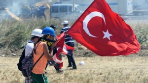 People try to protect themselves as riot and paramilitary police officers fire tear gas and use water cannons to disperse protesters outside the Silivri jail complex in Silivri, Turkey, on Monday, August 5, 2013, near where verdicts in the Ergenekon trial are being handed down. (AP Photo)