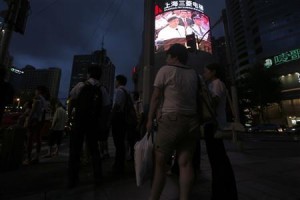 People watch a news broadcast of ousted Chinese politician Bo Xilai standing trial on a screen at a junction in Shanghai on August 22, 2013. (REUTERS/Aly Song)