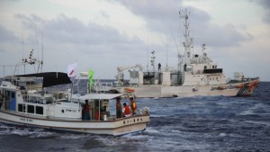 A Japanese Coast Guard vessel (R) sails alongside Japanese activists' fishing boat (L) near a group of disputed islands called Diaoyu by China and Senkaku by Japan, early Sunday, August 18, 2013. (AP Photo/Emily Wang)
