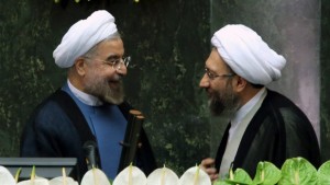 Iranian president Hassan Rouhani (L) greets judiciary chief Sadeq Larijani (R) at the Iranian parliament in Tehran, Iran, on Sunday, August 4. (EPA/ABEDIN TAHERKENAREH)