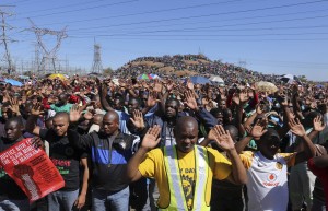 Miners gesture as they pray during the one-year anniversary commemorations to mark the killings of 34 striking platinum miners shot dead by police outside the Lonmin's Marikana platinum mine in Rustenburg, 62 miles (100 kilometers) northwest of Johannesburg, in this August 16, 2013, file photo. (Reuters/Siphiwe Sibeko)