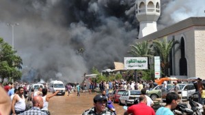 Smoke is seen above people gathering outside a mosque on the site of a powerful explosion in the northern Lebanese city of Tripoli on August 23, 2013. (AFP PHOTO/IBRAHIM CHALHOUB)
