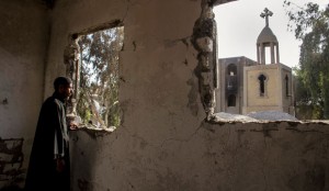 In this Sept. 3, 2013 photo, Egyptian priest Samuel Zaki views the damaged main church inside the Virgin Mary and St. Abraam Monastery that was looted and burned by Islamists, in Dalga, Minya province, Egypt. (AP/Roger Anis)