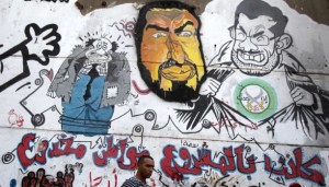 A man walks past graffiti depicting ousted Egyptian President Mohamed Mursi (R) and the Deputy Guide of the Muslim Brotherhood Khairat Al-Shater in downtown Cairo on September 24, 2013. The Arabic words read, "Liar project - Deluded citizen". (REUTERS/Amr Abdallah Dalsh)