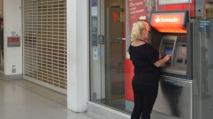 Customers use ATM machines at the Surrey Quays branch of Santander Bank while the premise is closed, in Surrey Quays, south London, on September 13, 2013. (REUTERS/Toby Melville)