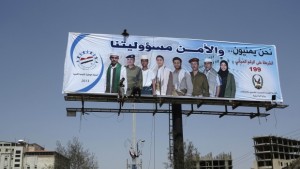 Workers put up a billboard urging citizens to cooperate with security authorities in Sanaa on September 30, 2013. The billboard reads, "We are Yemenis and security is our responsibility." (REUTERS/Khaled Abdullah)