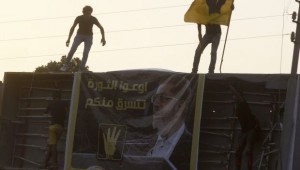 Members of the Muslim Brotherhood and supporters of ousted Egyptian president Mohamed Mursi climb a structure to hang up a poster of Mursi during a protest against the military and interior ministry near El-Thadiya presidential palace in Cairo on September 20, 2013. The poster reads, "Do not let the revolution steal from you". (REUTERS/Amr Abdallah Dalsh)