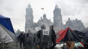 Riot policemen walk in front of the cathedral on the Zocalo after dispersing demonstrators on the Zocalo in Mexico City. (REUTERS/Tomas Bravo)