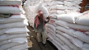An Indian laborer carries a sack of sugar at a warehouse in Jammu, India, on Thursday, August 22, 2013. (AP Photo/Channi Anand)