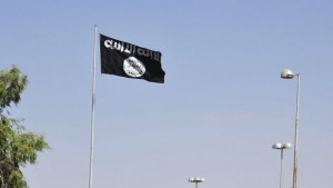 Vehicles drive past a flag of the al-Qaeda linked Islamic State of Iraq and the Levant, fluttering at the entrance to the city of Raqqa, eastern Syria, on October 4, 2013. (REUTERS/Nour Fourat)
