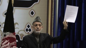 Afghan President Hamid Karzai holds a copy of a weekly security report during the last day of the Loya Jirga in Kabul, Afghanistan, Sunday, November 24, 2013 (AP Photo/Rahmat Gul)