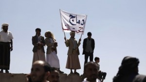 A supporter of an Islamic Salafist movement, center, holds a banner with Arabic writing that reads, "Dammaj under the fire," as he and others take part in a demonstration in Sana'a to denounce shelling in Dammaj by Houthi rebels on Saturday, November 2, 2013. (AP Photo/Hani Mohammed)