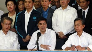 Thailand's opposition leader and former Prime Minister Abhisit Vejjajiva (C) speaks during a news conference as his party members listen at the Democrat Party headquarters in Bangkok December 21, 2013. Thailand's opposition Democrat Party will boycott a Feb. 2 election, its leader said on Saturday, a move that could deepen uncertainty amid anti-government protests seeking to topple the government and thwart the poll. REUTERS/Chaiwat Subprasom (THAILAND - Tags: POLITICS ELECTIONS)