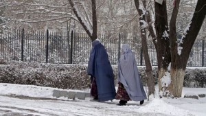 Afghan women walk on a snow covered street in Kabul, Afghanistan, Monday, Dec. 30, 2013. Kabul has been experiencing below freezing weather and snow. (AP Photo/Rahmat Gul)