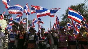Thai anti-government protesters march with country's flags while heading to shut down the office of the National Economic and Social Development Board (NESDB) Thursday, January 14, 2014 in Bangkok, Thailand. (AP Photo/Wason Wanichakorn)