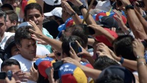 Leopoldo Lopez, left, an ardent opponent of Venezuela's socialist government led by President Nicolas Maduro, is surrounded by supporters during a demonstration before turning himself in to authorities, in Caracas, on February 18, 2014. (AFP Photo/Raul Arboleda)