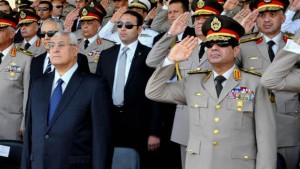 In this July 22, 2013 file photo released by the Egyptian Presidency, Egypt's interim President Adly Mansour, front left, Defense Minister Field Marshal Abdel-Fattah El-Sisi, front right, and other military officers listen to the national anthem during a medal ceremony at a military base in eastern Cairo. (AP Photo/Sheriff Abd El Minoem, Egyptian Presidency/File)