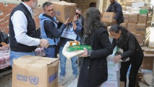 A handout picture released by the official Syrian Arab News Agency (SANA) on February 1, 2014 shows residents of Syria's besieged Yarmuk Palestinian refugee camp, south of Damascus, receiving food parcels from the United Nations Relief and Works Agency (UNRWA). (AFP Photo/HO/SANA)