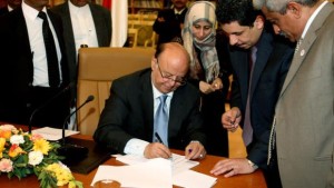 In this photo provided by Yemen's Defense Ministry, Yemeni President Abd Rabbuh Mansur Hadi signs the final approval on transforming Yemen into a federal state of six regions in Sana’a Yemen, on Monday, February 10, 2014. (AP Photo/Yemen's Defense Ministry)
