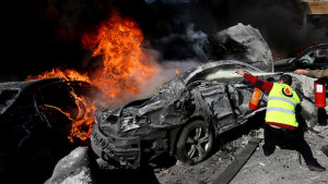 A Hezbollah civil defense worker extinguishes a burned car at the site of an explosion, near the Kuwaiti Embassy and Iran's cultural center, in the suburb of Beir Hassan, Beirut, Lebanon, Wednesday, Feb. 19, 2014. A blast in a Shiite district in southern Beirut killed at least two people on Wednesday, security officials said — the latest apparent attack linked to the civil war in neighboring Syria. (AP Photo/Hussein Malla)