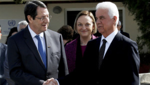 Cyprus president Nicos Anastasiades, left, and Turkish Cypriot leader Dervis Eroglu shake hands as U.N. Secretary-General's Special Representative to Cyprus Lisa Buttenheim, center, smiles after their meeting at a UN compound in the UN buffer zone in the divided capital Nicosia, Cyprus, Tuesday, Feb. 11, 2014. The leaders of Cyprus' Greek and Turkish Cypriot communities are embarking on a new round of talks aimed at achieving the long-elusive goal of reunifying the ethnically split island nation. (AP Photo/Petros Karadjias)