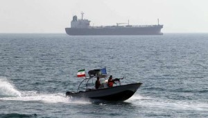 A picture taken on July 2, 2012 shows Iranian Revolutionary Guards driving a speedboat in front of an oil tanker at the port of Bandar Abbas. (AFP PHOTO/ATTA KENARE)