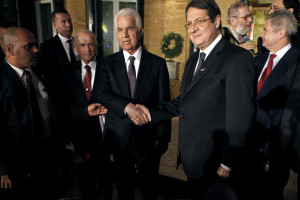 In this November 25, 2013 file photo, Cyprus president Nicos Anastasiades, right, and Turkish Cypriot leader Dervis Eroglu, left, shake hands after their meeting in the divided capital Nicosia, Cyprus. (AP Photo/Petros Karadjias, File)
