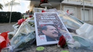 Flowers are laid at a memorial for slain opposition leader Chokri Belaid (portrait) set up at the site where he was murdered one year ago, on February 6, 2014 in Tunis. Tunisians today marked 12 turbulent months since the assassination of opposition politician Chokri Belaid, with his family still demanding to know what happened despite the alleged assassin being shot dead this week. AFP PHOTO / FETHI BELAID