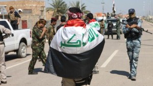 Wrapped in the Iraqi flag, police and security gather along Street 60 after the southern districts of the city of Ramadi, the capital of the Anbar province, were recaptured by government forces from militants, on March 16, 2014. (AFP Photo/Azhar Shallal)
