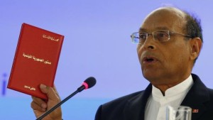 Tunisia President Moncef Marzouki holds a copy of the Tunisian new constitution during his address to the 25th session of the Human Rights Council at the United Nations in Geneva, Switzerland, on March 3, 2014. (Reuters/Denis Balibouse)