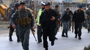 Afghan policemen run as they arrive near the Afghan election commission during an attack on the election centre in Kabul on March 29, 2014. (AFP PHOTO/WAKIL KOHSAR)