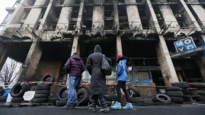 epa04109563 Ukrainians look on a burned during protests building near of the Independence Square in Kiev, Ukraine, 04 March 2014. Russian President Vladimir Putin met with journalists at his Novo-Ogaryovo residence outside Moscow to explain his position on the Ukrainian events, saying that he sees no need to send Russian troops to Ukraine now, calling it a 'last resort.' The Russian army reportedly had occupied key sites in the autonomous region of Crimea, where a majority of the population is ethnic Russian two days earlier. Troops surrounded several small military outposts and demanded Ukrainian troops disarm. EPA/SERGEY DOLZHENK