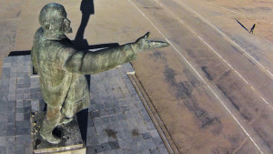 In this aerial photo a woman walks past a statue of Soviet Union founder Vladimir Lenin at the Russian leased Baikonur cosmodrome, in Kazakhstan, Thursday, March 27, 2014. Baikonur is the world's first and largest operational space launch facility. (AP Photo/Dmitry Lovetsky)