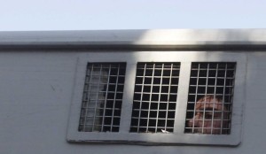 A Syrian detainee who was arrested over participation in the protests against Syrian President Bashar Al-Assad's regime is seen in a prison vehicle at the Damascus police leadership building to sign his release papers on July 11, 2012. (Reuters)