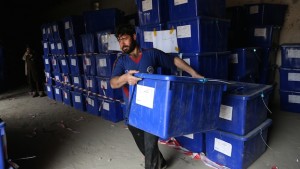 In this Wednesday, April 2, 2014, file photo an Afghan election worker carries a ballot box at an election commission office in Jalalabad, east of Kabul, Afghanistan. (AP Photo/Rahmat Gul, File)