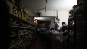 A supermarket seller stands near an emergency light during on of Cairo's many power outages at his shop on April 16, 2014. (REUTERS/Amr Abdallah Dalsh)