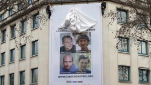 A poster calling for the release of French journalists Didier Francois, Edouard Elias, Nicolas Henin and Pierre Torres is installed on the facade of the Ile de france regional council headquarters in Paris January 6, 2014. (REUTERS/BENOIT TESSIER)