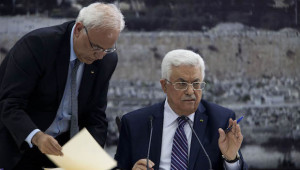 In this Tuesday April 1, 2014, photo, Palestinian President Mahmoud Abbas (R), joined by Palestinian chief peace negotiator Saeb Erekat, signs an application to the UN agencies in the West Bank city of Ramallah. (AP Photo/Majdi Mohammed, File)