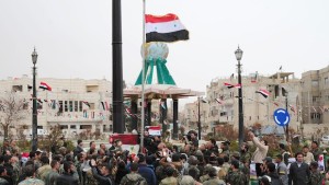 A handout picture released by the official Syrian Arab News Agency (SANA) on March 17, 2014, shows Syrian pro-government forces and supporters of Syrian President Bashar Al-Assad hoisting their national flag in the western town of Yabrud. (AFP PHOTO/SANA/HO)