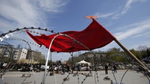 A flag flutters in the wind over barricades at the regional administration building that had been seized earlier, in Donetsk, Ukraine, on April 18, 2014. (AP Photo/Sergei Grits)