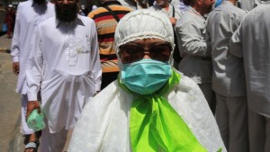 A Muslim pilgrim wears a surgical mask to help prevent infection from a respiratory virus known as the Middle East Respiratory Syndrome (MERS) in the holy city of Mecca, Saudi Arabia, on May, 13, 2014. (AP Photo/Hasan Jamali)