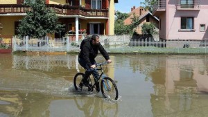 A man rides a bicycle through flooded streets of Svilajnac, 120 kilometers south of Belgrade, on May 20, 2014. (AFP PHOTO / SASA DJORDJEVIC)
