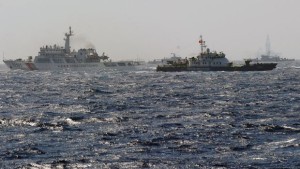 This picture taken from a Vietnam Coast Guard ship on May 14, 2014 shows a Vietnam Coast Guard ship (2nd R, dark blue) trying to make way amongst several China Coast Guard ships near to the site of a Chinese drilling oil rig (R, background) being installed at the disputed water in the South China Sea off Vietnam's central coast. Vietnam National Assembly's deputies gathered for their summer session are discussing the escalating tension with China over the South China Sea's contested water. AFP PHOTO/HOANG DINH Nam