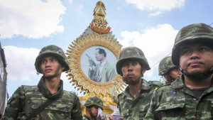 Thai soldiers gather under a portrait of King Bhumibol Adulyadej after anti-government protesters were removed off the site following the coup declared at Democracy Monument in Bangkok, Thailand, on May 23, 2014. (EPA/DIEGO AZUBEL)