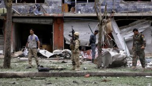 Afghan security personnel investigate the site of a suicide attack that struck the convoy of presidential candidate Abdullah Abdullah in Kabul, Afghanistan, on Friday, June 6, 2014. (AP Photo/Rahmat Gul)